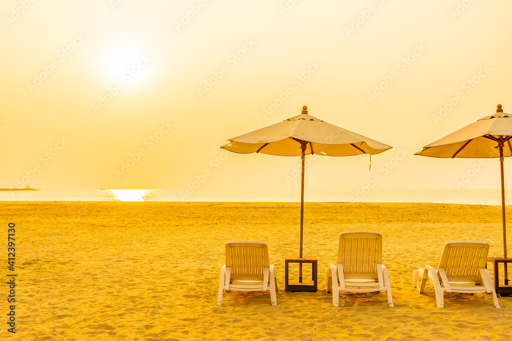 Umbrella and chair around outdoor beach sea ocean at sunset or sunrise