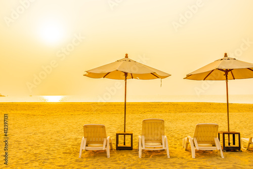 Fototapeta Naklejka Na Ścianę i Meble -  Umbrella and chair around outdoor beach sea ocean at sunset or sunrise