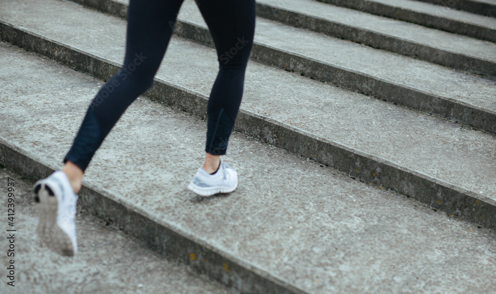 Female athlete running on steps outdoors Female athlete running on steps outdoors