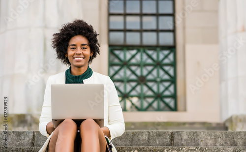 Business woman using her laptop outdoors.