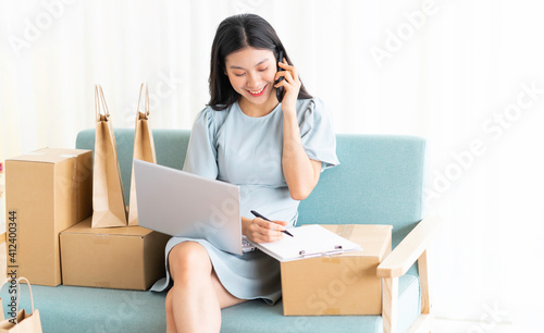 Young asian girl sitting at home selling online © Timeimage