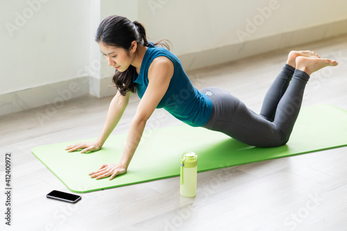 Young asian girl doing exercise on the floor alone