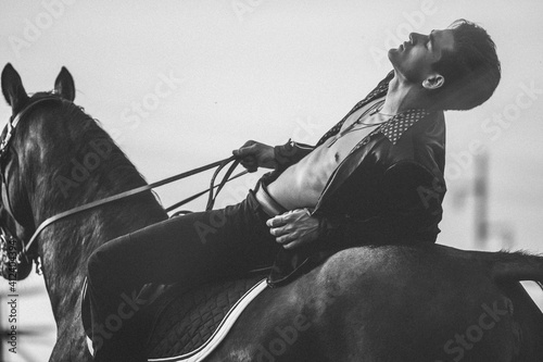 emotions,handsome young man dressed in black with a black horse