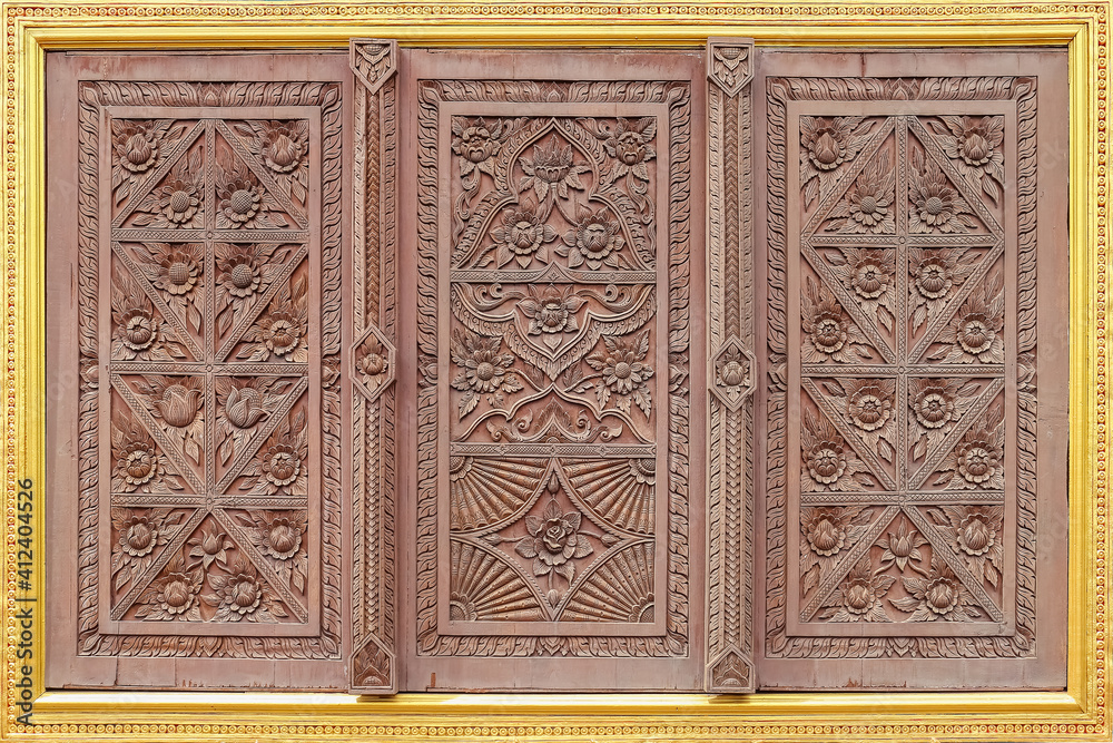 Old wooden windows carved in golden stucco frames. In the walls of temples in thailand