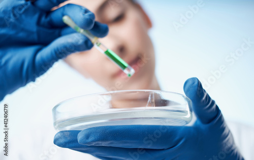 doctor in medical gloves and glasses holds a flask with liquid laboratory chemical element