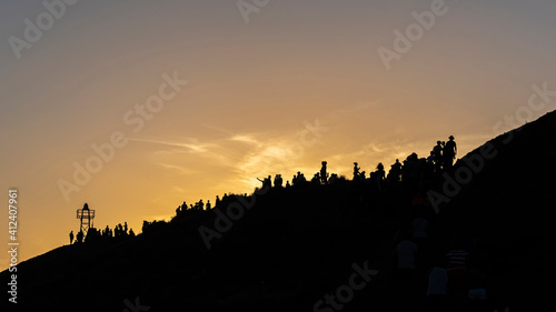 Silhouettes of people on a hill gazing the sunset