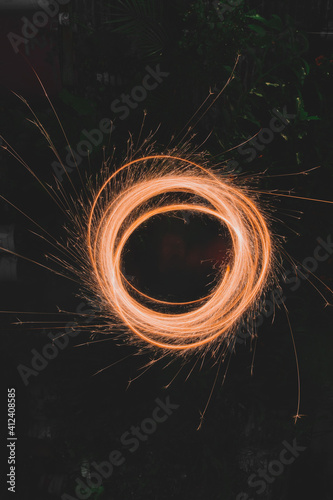 niña girando bengalas en forma de espiral formando líneas de luz con forma circular tomadas en larga exposición 