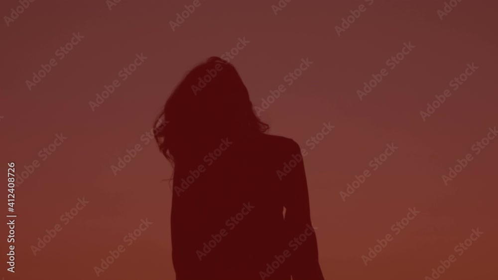 silhouette of young carefree woman dancing moving her head - slow motion silhouette of young carefree woman dancing moving her head - slow motion