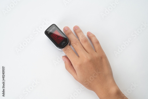 Top view of Pulse Oximeter, finger digital device to measure person's oxygen saturation. Reduced oxygenation is an emergency sign of pneumonia caused by flu or novel coronavirus. Device on Fingertip (ID: 412409517)