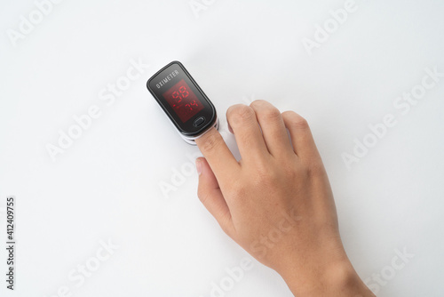 Top view of Pulse Oximeter, finger digital device to measure person's oxygen saturation. Reduced oxygenation is an emergency sign of pneumonia caused by flu or novel coronavirus. Device on Fingertip (ID: 412409755)