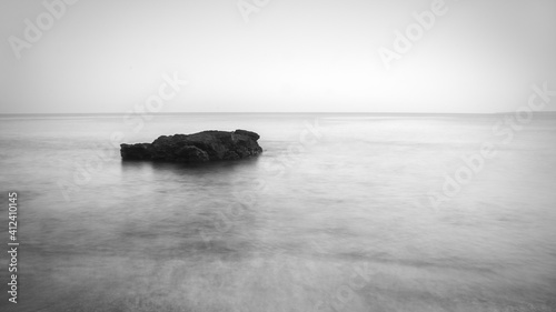 Minimalist seascape with rock at B&W photo
