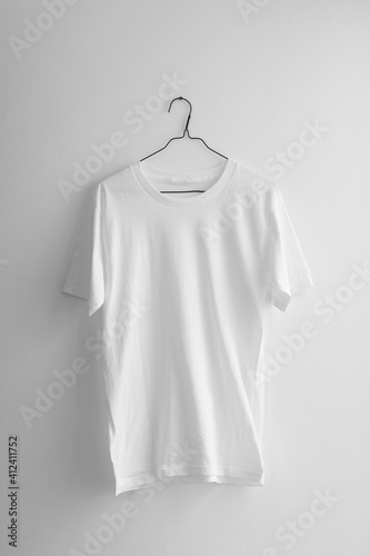 Plain white t-shirt hanging on the wall.