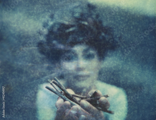 Polaroid portrait of a young woman wearing a dried flowers and leaves crown. photo