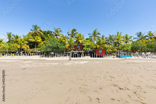 Panama Armuelles, red house on stilts among the palm trees of the beach © Marco