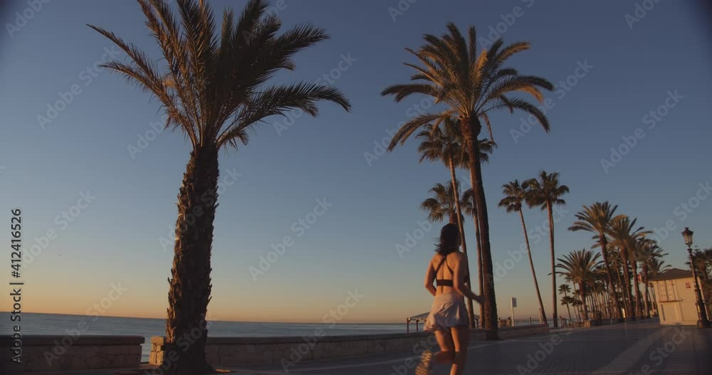 Athletic Young Woman Running Along Beach Athletic Young Woman Running Along Beach
