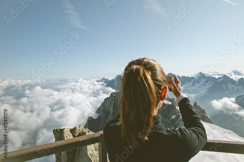 Mountaineer woman taking photos of the Alps landscape. Chamonix, France. photo