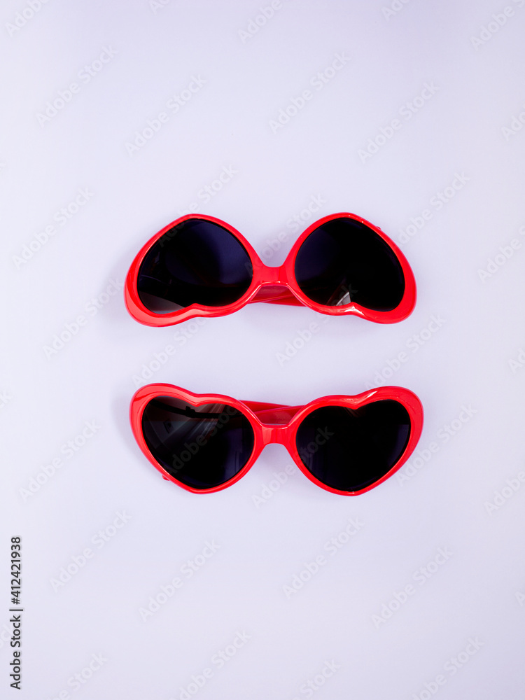 Two heart shaped red sunglasses on lilac background Two heart shaped red sunglasses on lilac background