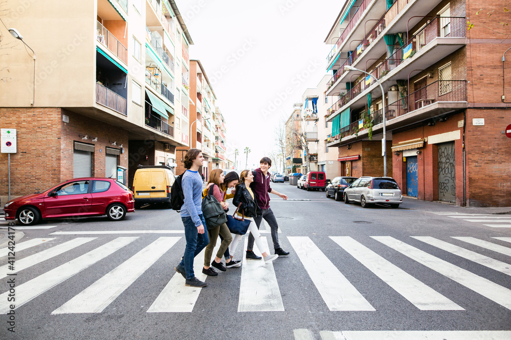 Side view of group of teen friends crossing the street. Side view of group of teen friends crossing the street.