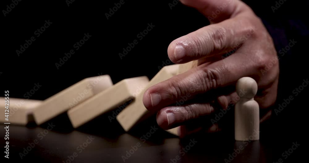 4K Video slow close up hand stop domino effect to make employee icon fall . business concept of try to stop the domino effect