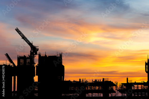 Silhouette of Engineer and worker on building site, construction site with clipping path sunset background for concepts