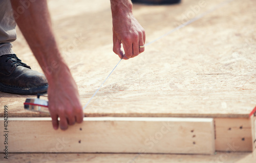 Construction: Worker Snapping a Chalk Line to Mark Wood photo