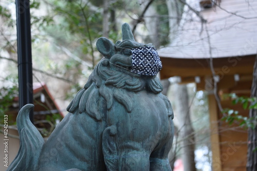 A guardian dog of a shrine wearing a mask for preventing new corona infection.