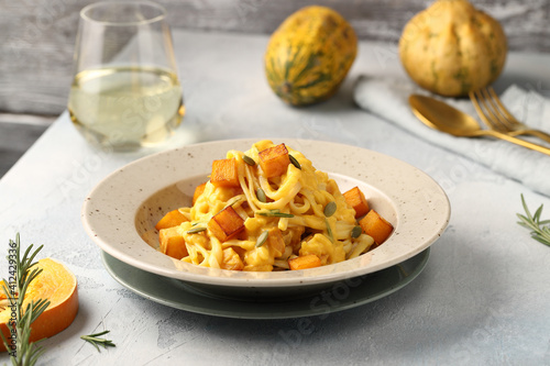 Linguine pasta with pumpkin creamy sauce, rosemary leaves and roasted pumpkin cubes, garnished with pumpkin seeds