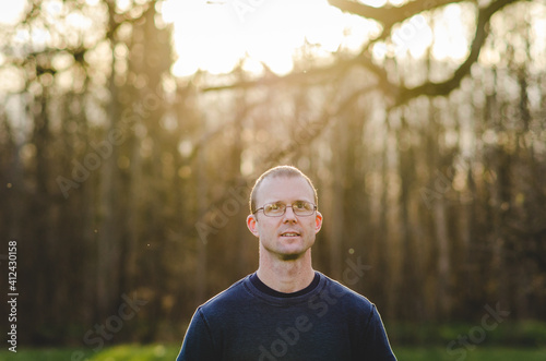 Man standing outside of woods at sunset photo