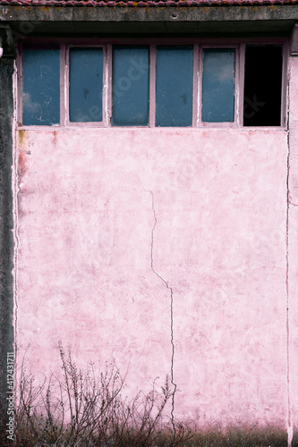 Abandoned building with windows on top, one of them broken photo