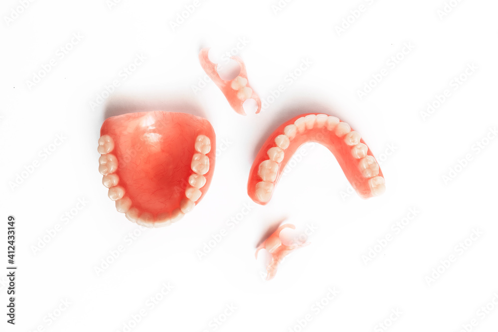 Dentures on a white background. Close-up of dentures. Full removable plastic denture of the jaws. Prosthetic dentistry. False teeth. Close-up of plastic dentures. Teeth on a white background