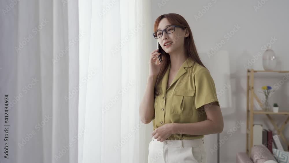 female manager standing with mobile is scratching her face gently and talking with exaggerated gesture. female manager standing with mobile is scratching her face gently and talking with exaggerated gesture.