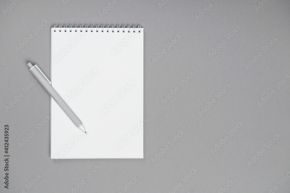 a notepad whit pen on a gray background a notepad whit pen on a gray background