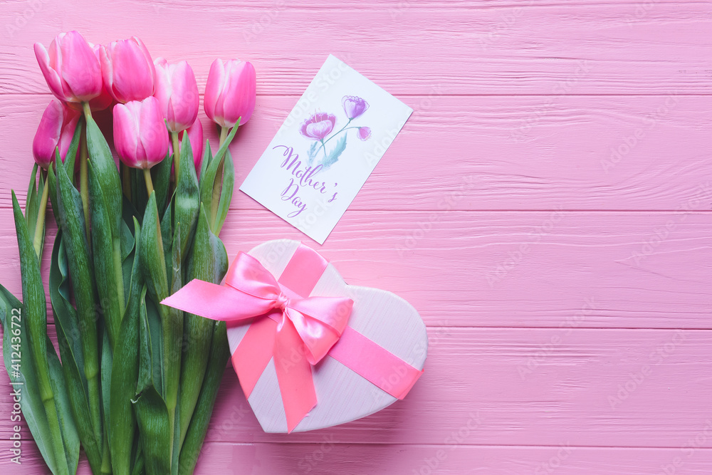Beautiful flowers, gift and greeting card for Mother's Day on color wooden background