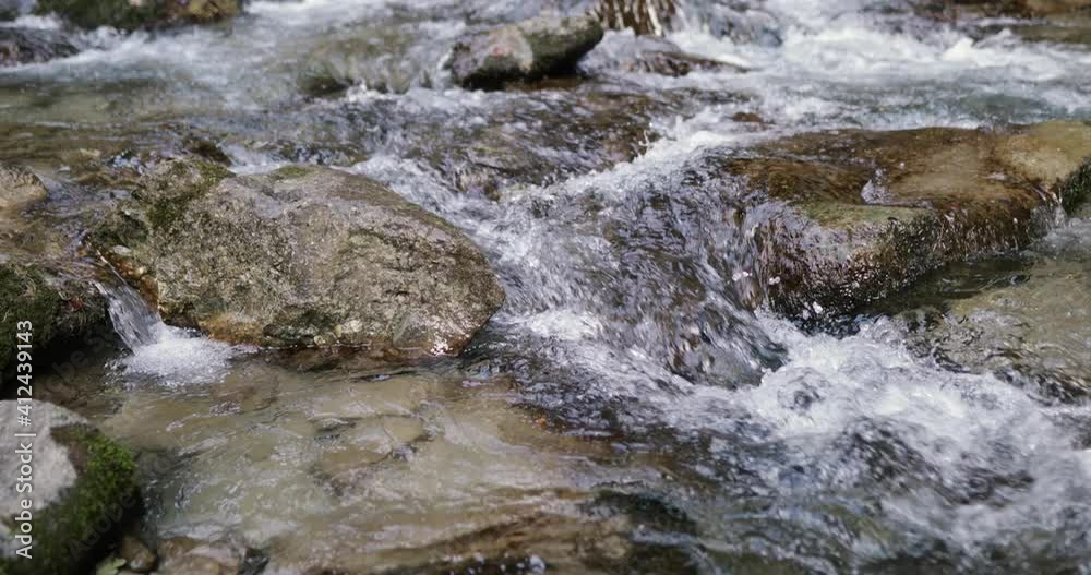 Details with the clear water of a running mountain stream during a cold and sunny winter day in the Romanian Carpathian Mountains. Details with the clear water of a running mountain stream during a cold and sunny winter day in the Romanian Carpathian Mountains.
