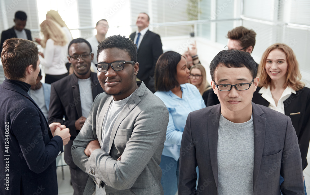 smiling young business man standing among his colleagues. smiling young business man standing among his colleagues.