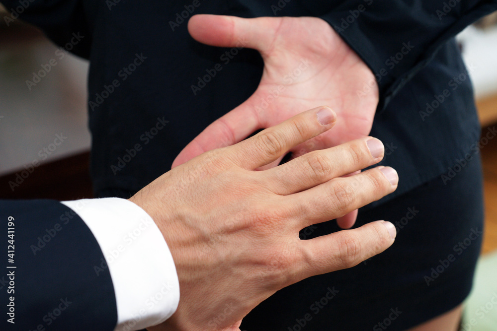 Obraz premium Businessman sexually harassing female colleague by trying to touch her