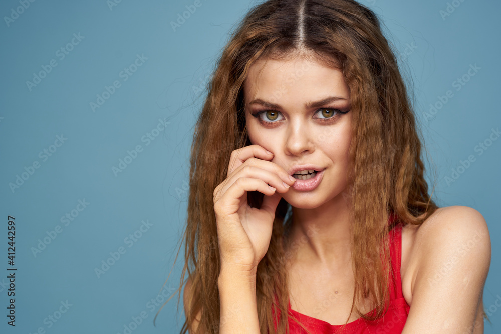 Fototapeta premium Attractive woman wavy hair charming look cosmetics elegant style blue background