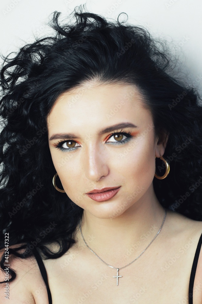 Beautiful young brunette model with bright make-up and curly hairstyle