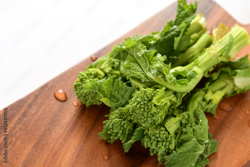 Fresh canola flowers on wooden cutting board. Fresh canola flowers on wooden cutting board.