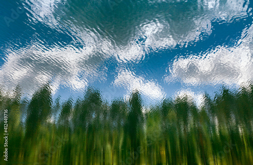 Background with forest and sky reflection in the lake.