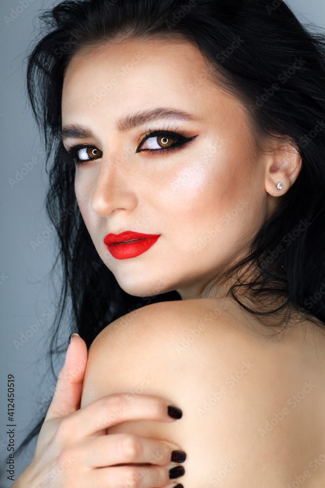 Beautiful young brunette model with bright make-up and long hair