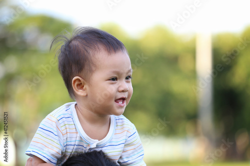 Asian boy is riding his mother's neck. © meepoohyaphoto