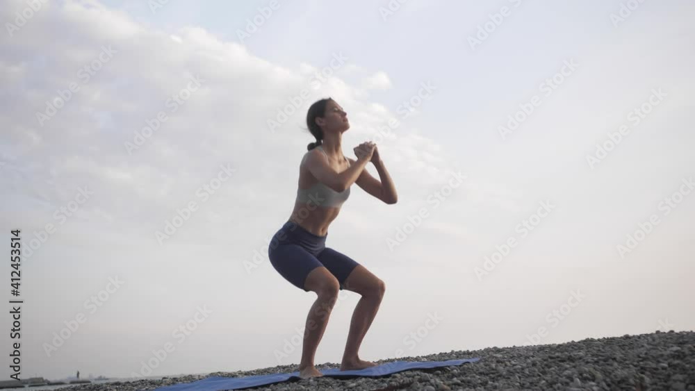 Outdoor fitness. Young woman doing squats Outdoor fitness. Young woman doing squats