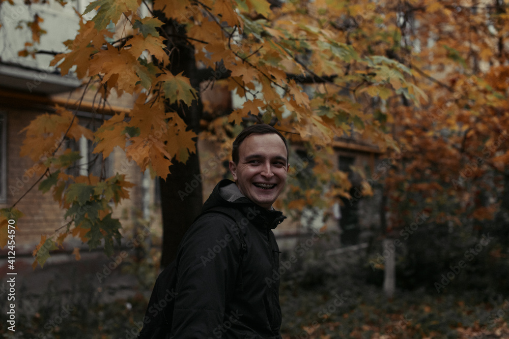 the guy smiles on the background of the gloomy Russian autumn the guy smiles on the background of the gloomy Russian autumn