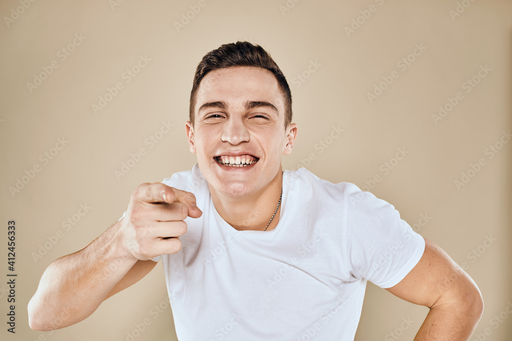 Cute emotional man white t-shirt gesture with hands cropped view beige studio background Cute emotional man white t-shirt gesture with hands cropped view beige studio background