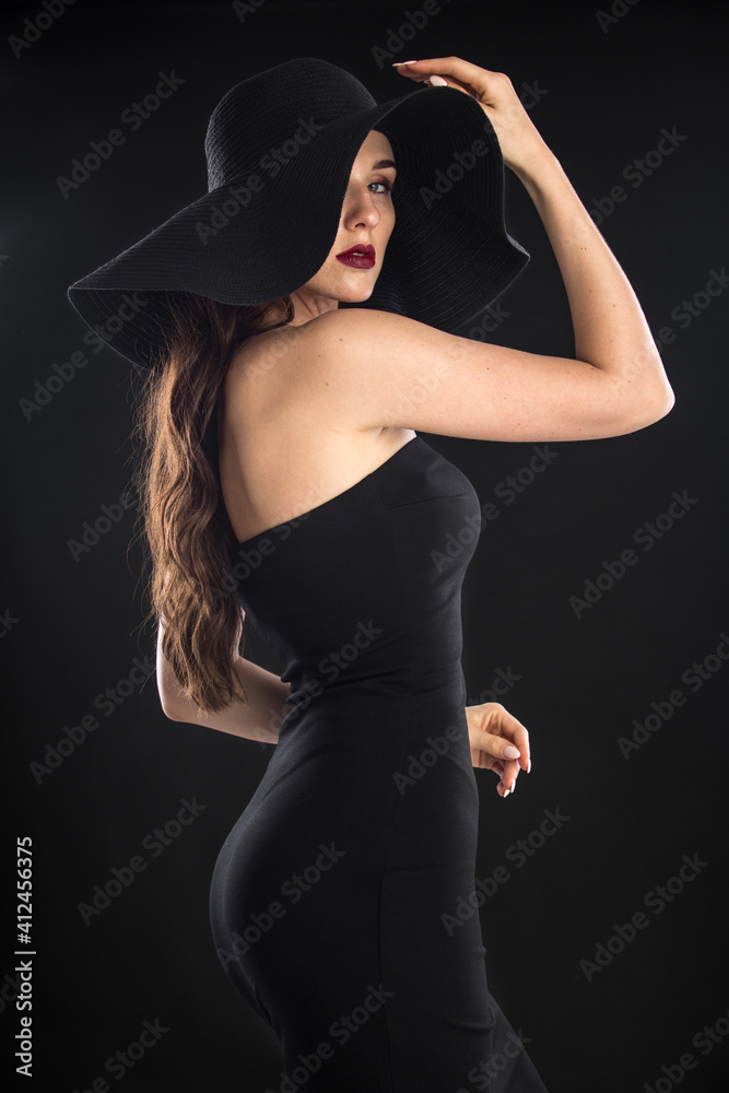 fashion portrait of a young and very beautiful girl in a black hat on a black background fashion portrait of a young and very beautiful girl in a black hat on a black background