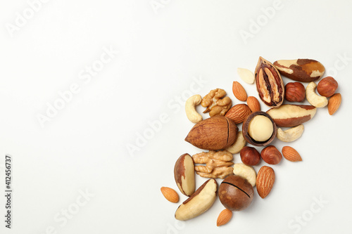 Different tasty nuts on white background, space for text