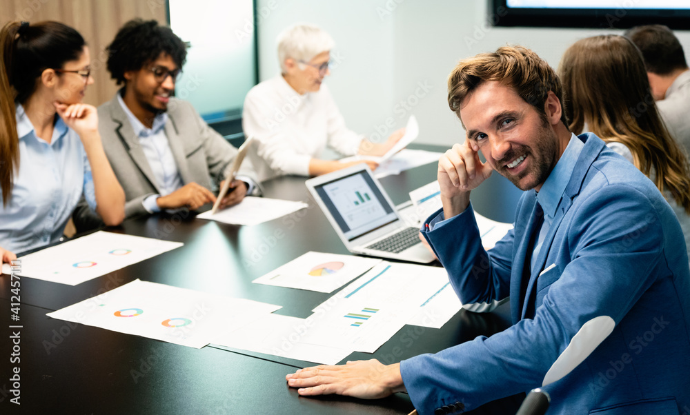 Fototapeta premium Group of business partners discussing documents and ideas at meeting