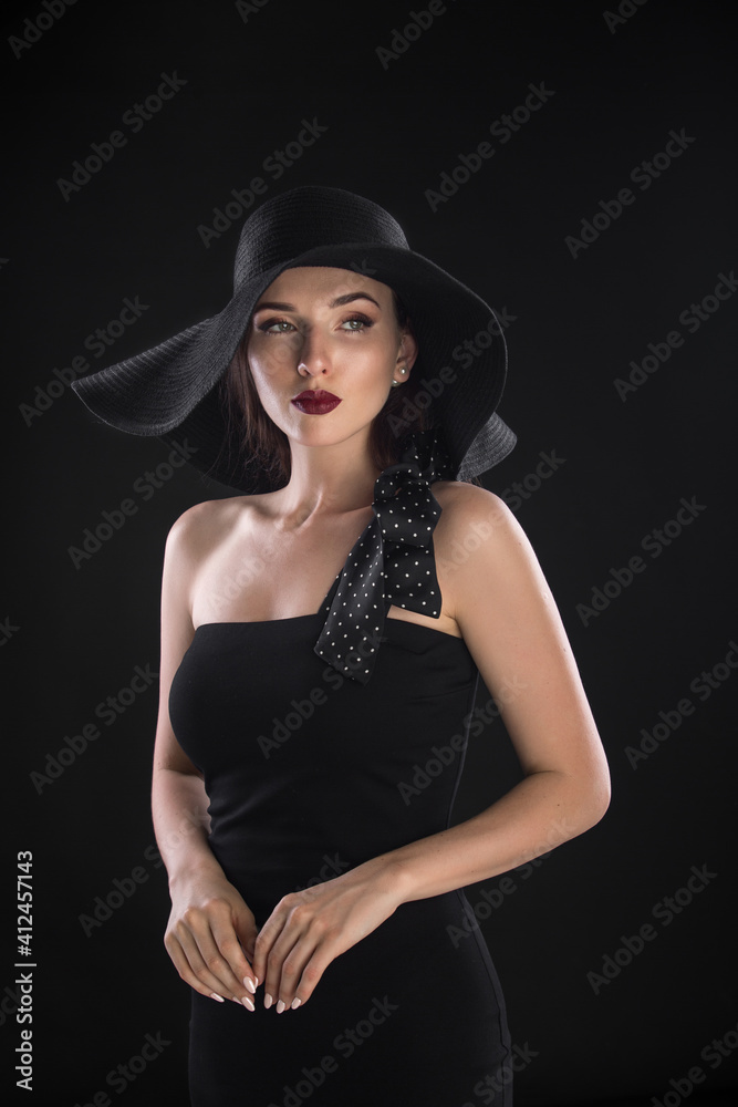 fashion portrait of a young and very beautiful girl in a black hat on a black background fashion portrait of a young and very beautiful girl in a black hat on a black background