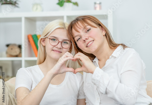 Two happy young girl show heart sign. LGBT concept
